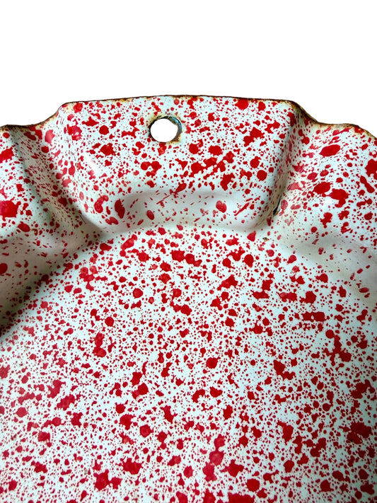 red and white splatterware dish with fluted rim