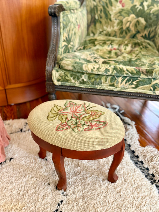 oval needlepoint footstool with pink and green leaf design