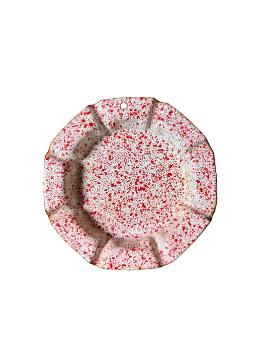 red and white splatterware dish with fluted rim