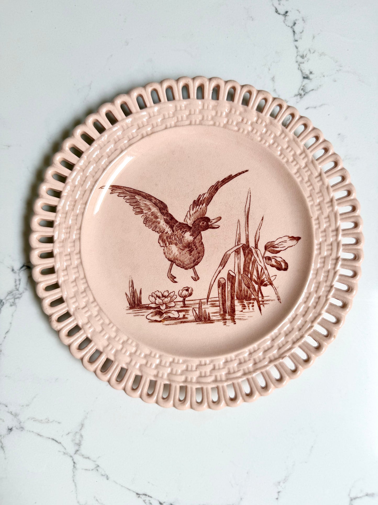 Longwy "Marly" earthenware plates with brown or blue transferware and a pierced basketweave border