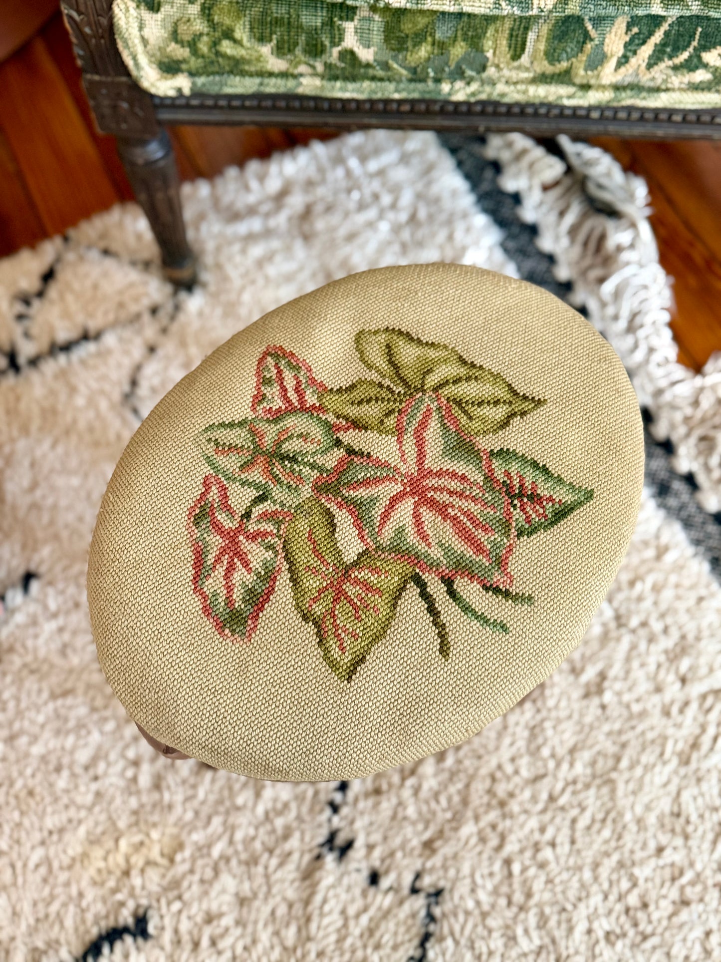 oval needlepoint footstool with pink and green leaf design