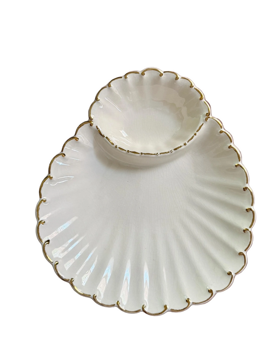 cream colored shell-shaped platter with gold trim